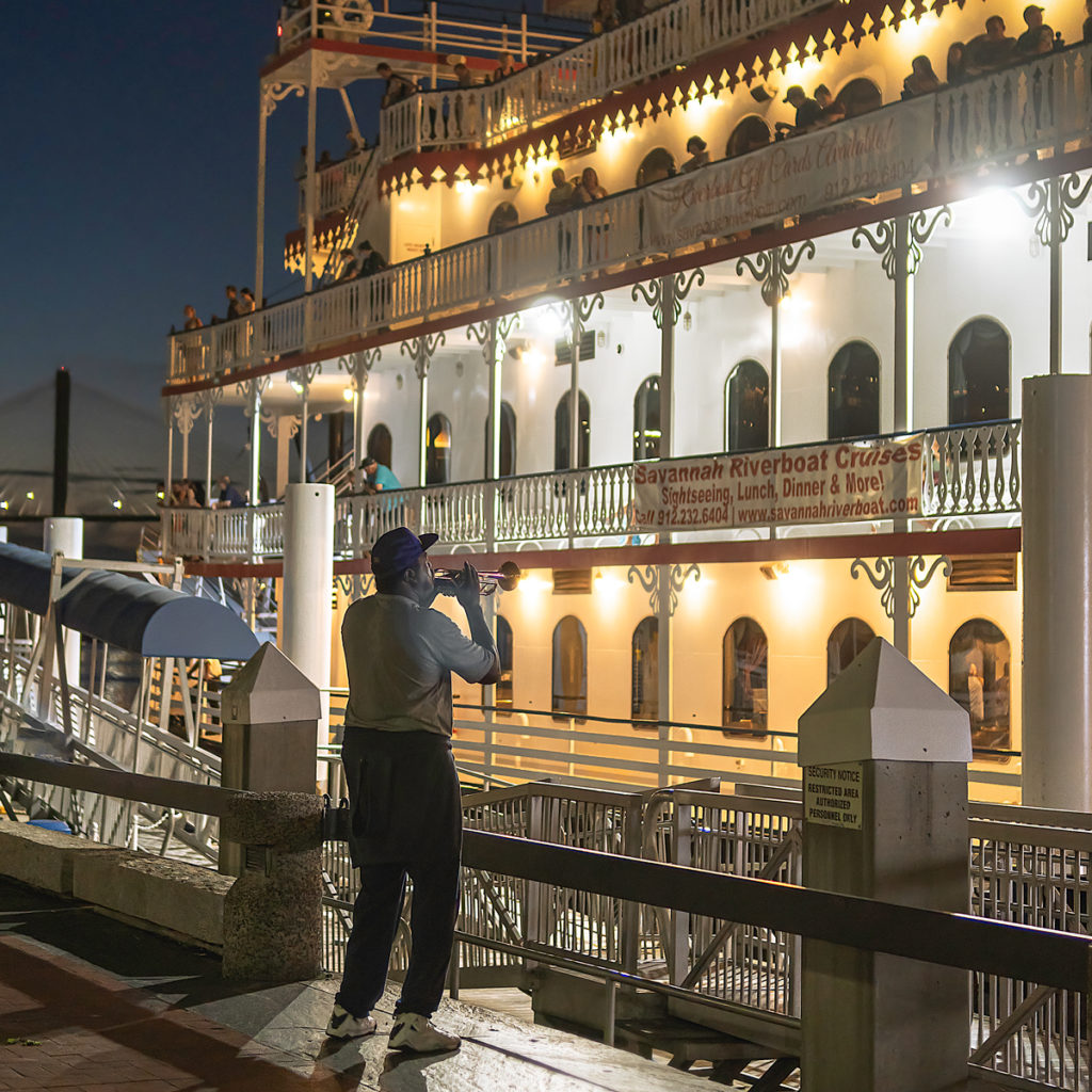 A trumpet player performs at night for the guests aboard the Savannah Riverboat Cruises.