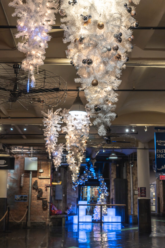 Upside down Christmas trees hang from the ceiling inside Chelsea Market.