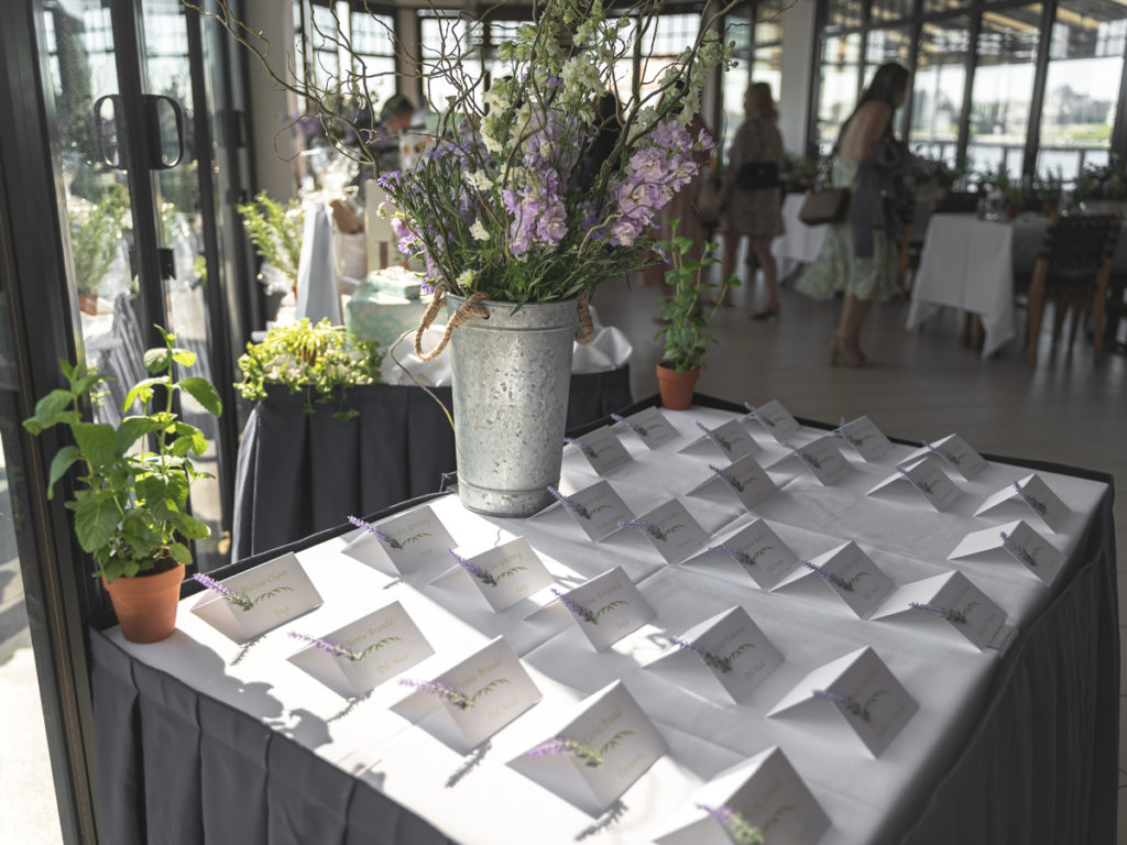 Name cards placed evenly on a table inside the Rum Runner with a bouquet of flowers.