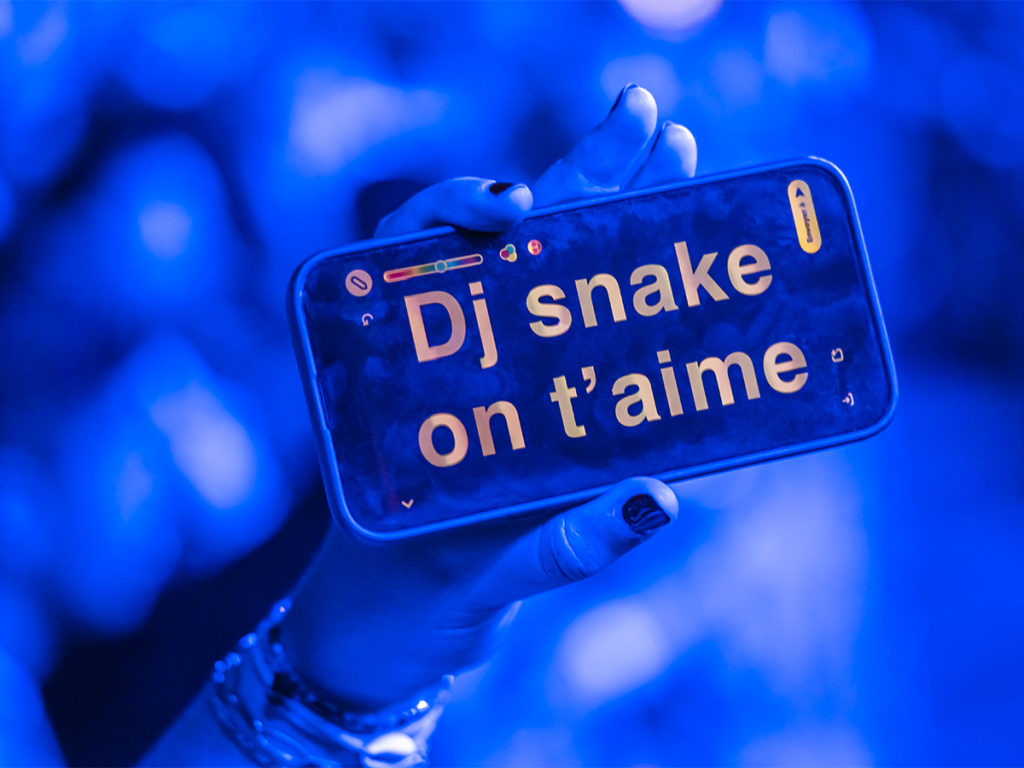 A fan's cellphone with the message "DJ Snake on t'aime"