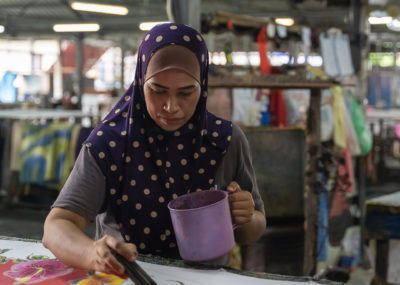 A painter hand paints fabric from scratch. Craft Batik is a cool shop to check out in Penang during a 2 week itinerary in Malaysia.