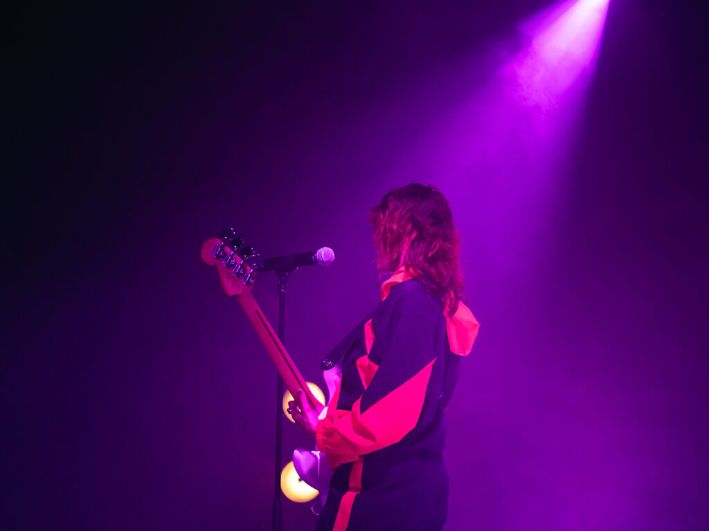 Concert photography of singer, UPSAHL, playing guitar on stage at Racket NYC in Chelsea.