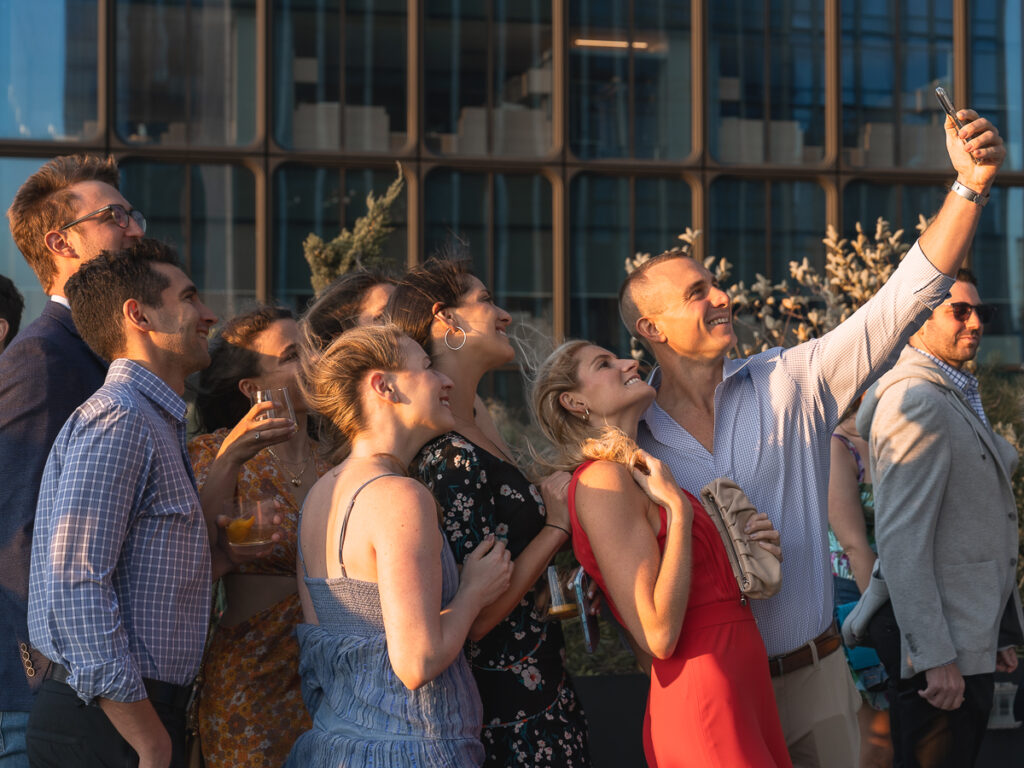 Candid moment of Electric Lemon event photography of friends taking a selfie in the wind.