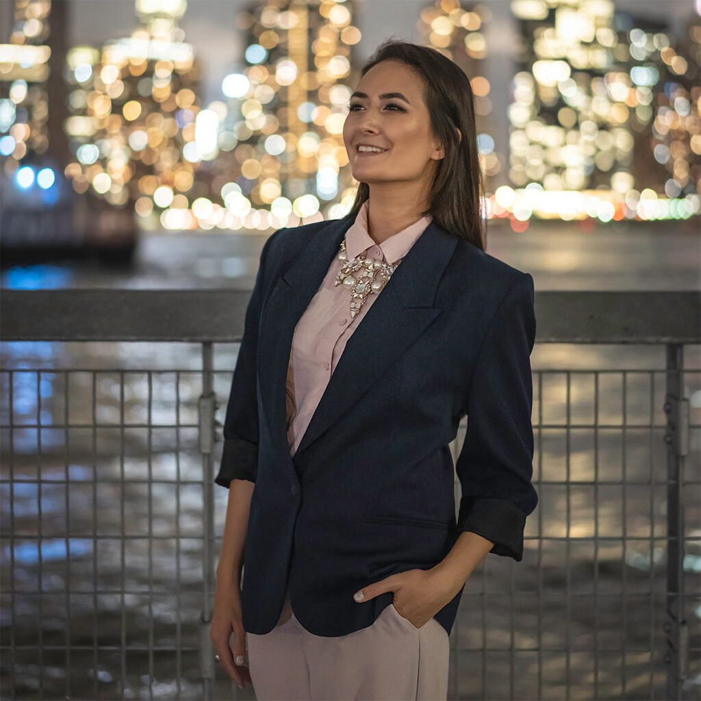 Natural light headshot with ambient bokeh from the NYC skyline in the background.