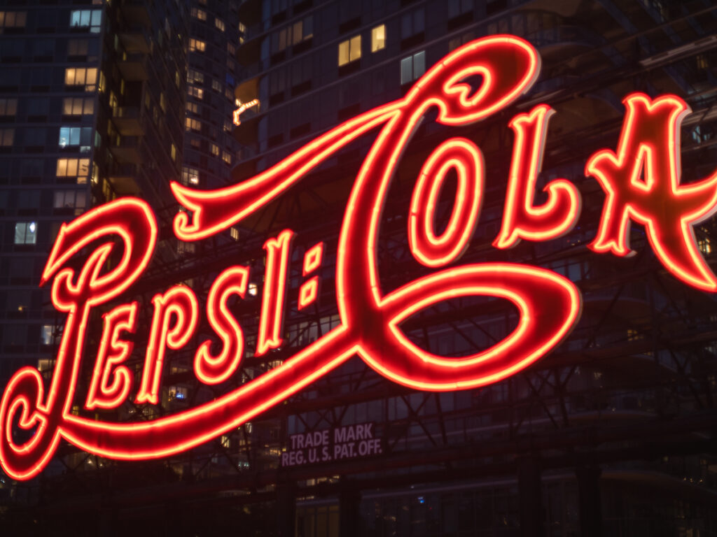 Neon Pepsi-Cola sign photographed with a Canon vintage camera lens.