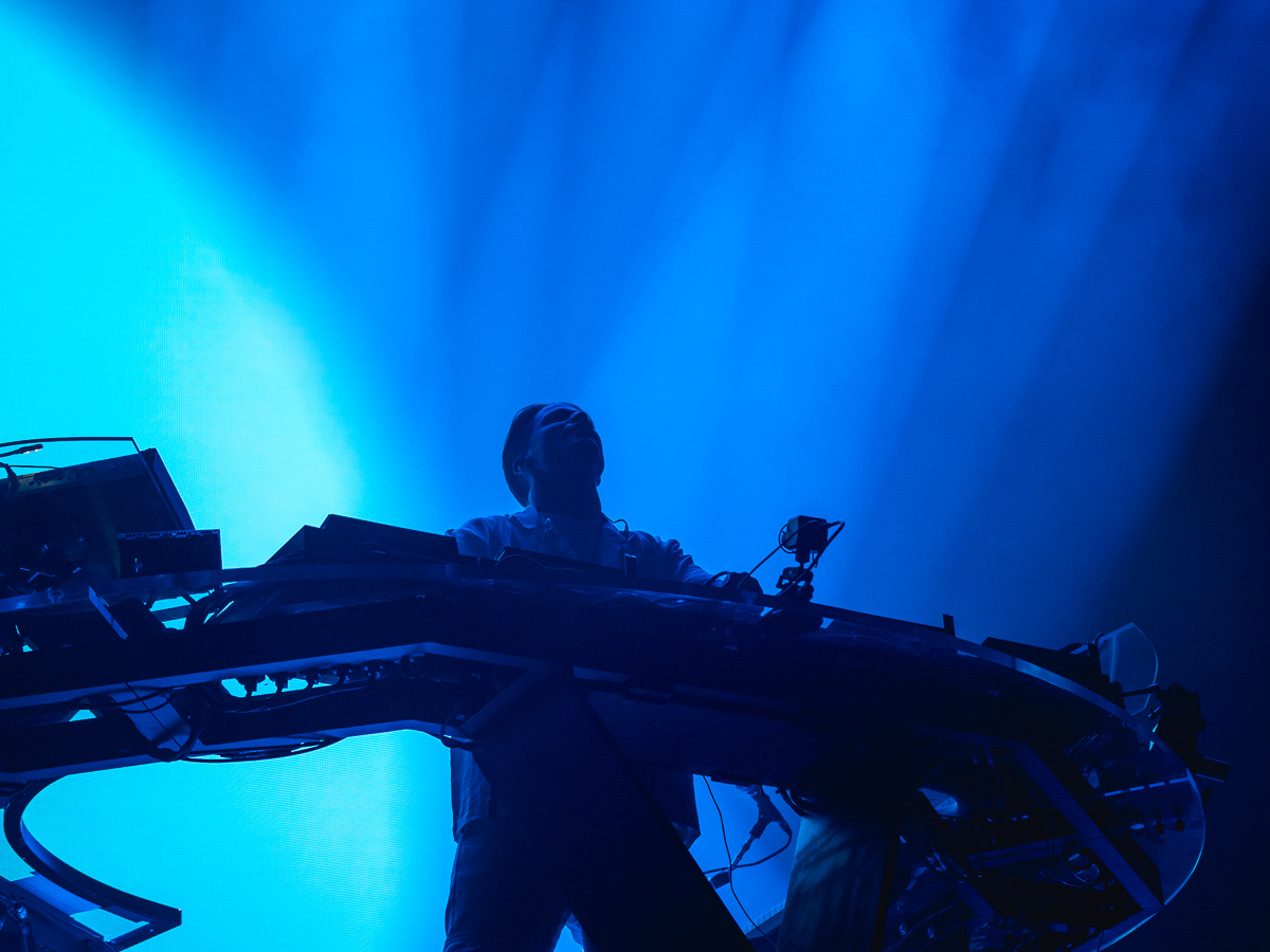 Silhouette of Kygo backlit in blue hues at Barclays Center.