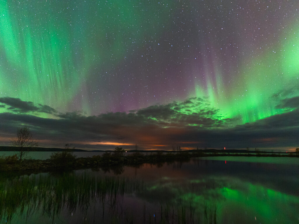 Photographing the Northern Lights in Lapland over a lake.