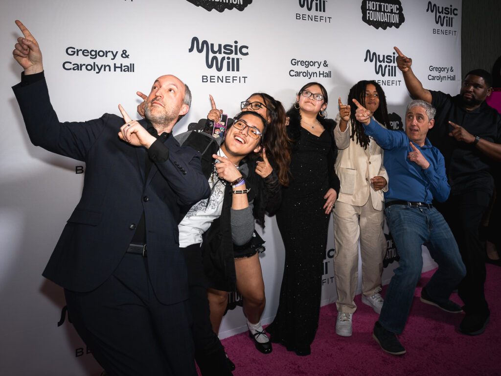 Dave Wish and Mike Wasserman pose with a bunch of students on the Music Will Benefit red carpet.