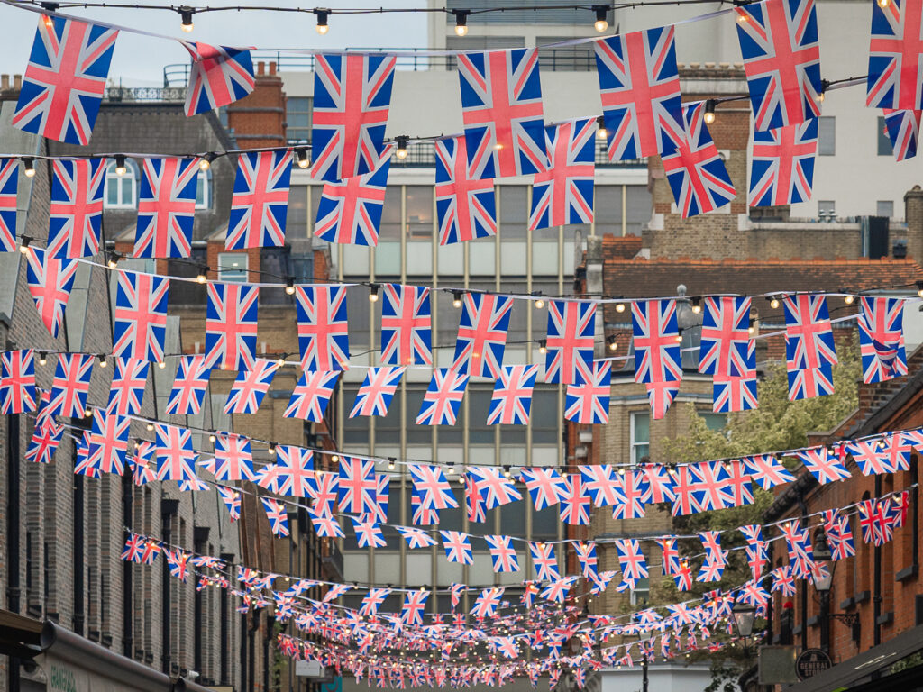 Rows of British flags line up a shopping district of Chelsea in London.