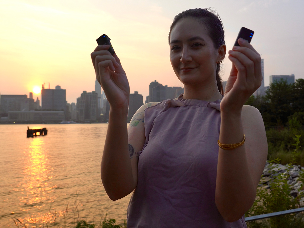 Holding up two transmitters of the Neewer CM28.