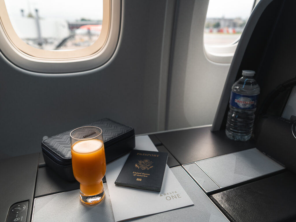 Delta One Business Class Seat with complimentary orange juice.