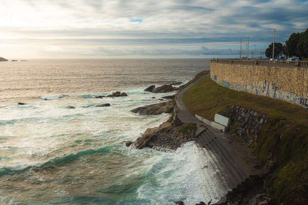 Coastal scene of the ocean crashing on the steps of A Coruna.
