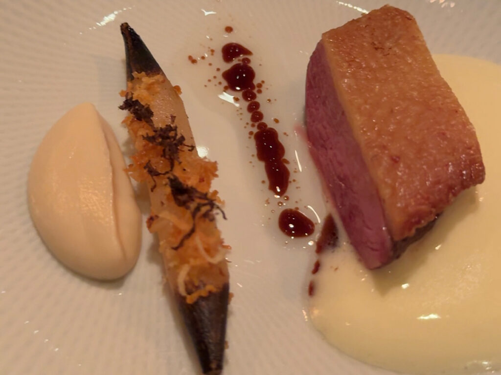 Precisely plated meat course with charred garnish and cream sauce from the Atera NYC