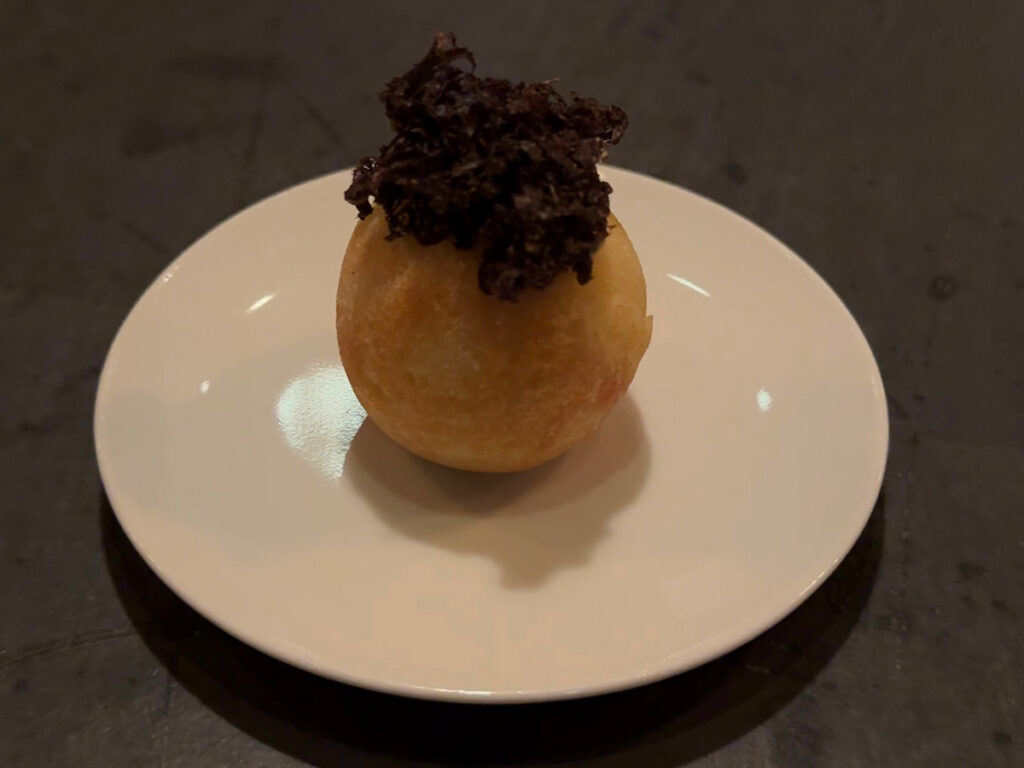 rispy fried puff topped with shaved black truffle, an amuse-bouche at Atera NYC