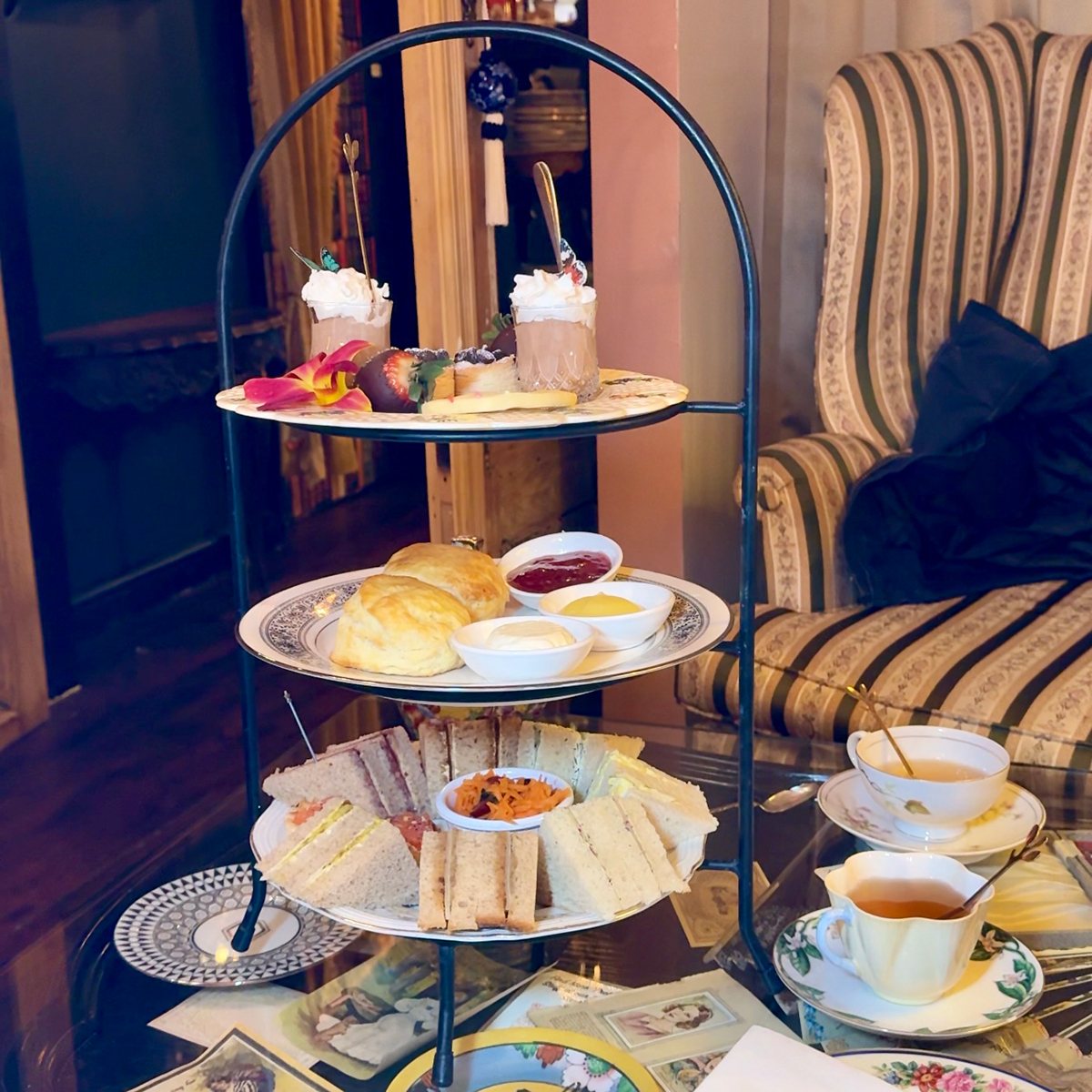 The Grand Vanderbilt afternoon tea service at Brooklyn High Low, featuring three tiers of finger sandwiches, scones with clotted cream and jam, and desserts