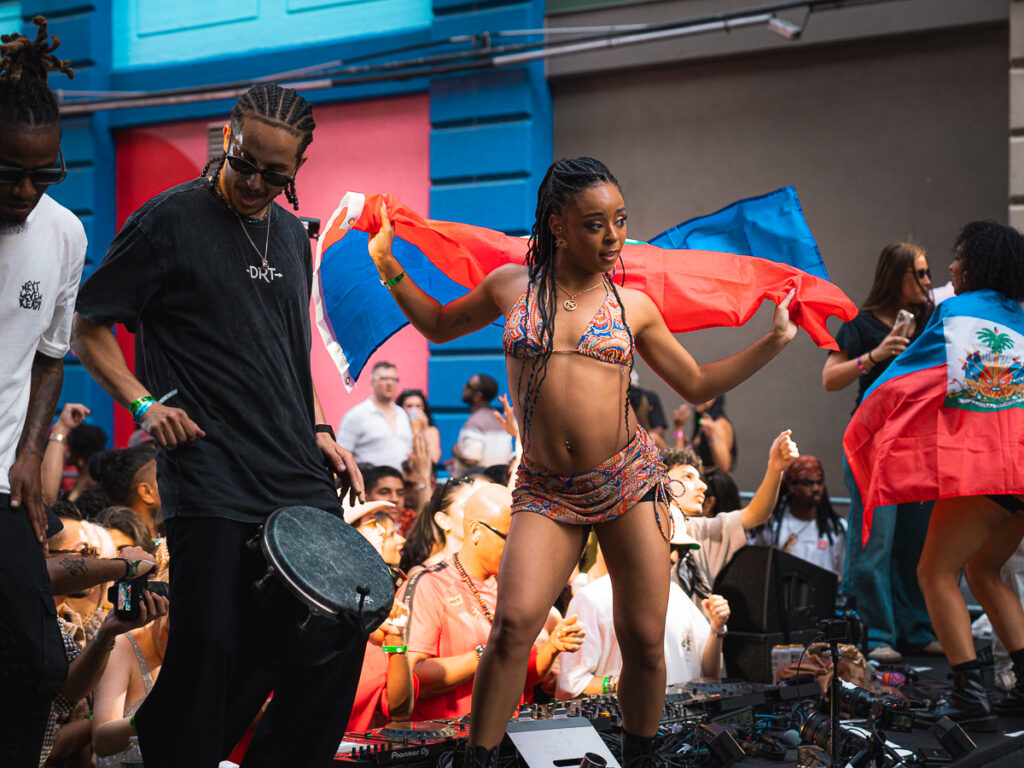 Dancer waving the Haitian flag on stage at Francis Mercier Solèy NYC Industry City Brooklyn