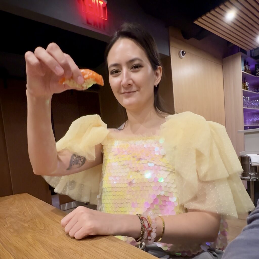 Holding up Oro King salmon nigiri eaten by hand at Shota Omakase Brooklyn.