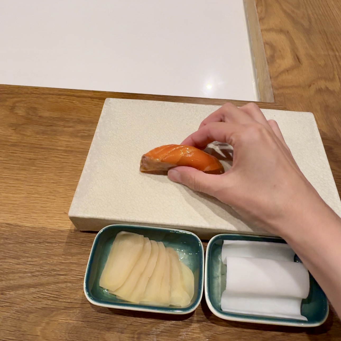 Oro King salmon nigiri eaten by hand at Shota Omakase Brooklyn.