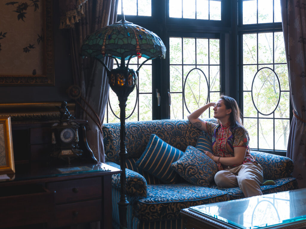 NIREDONAHUE seated by a leaded-glass window in the parlor at Old England Manor, Qingjing, Taiwan.