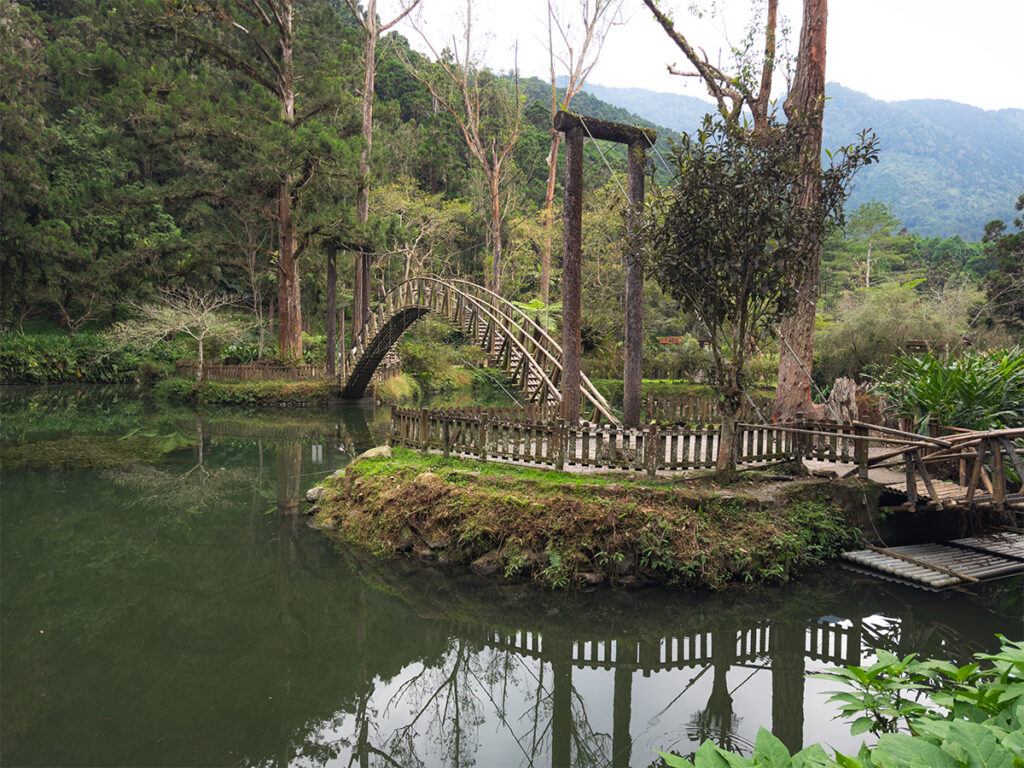 An arched bamboo bridge crossing University Pond in Xitou Nature Education Area, Nantou County.