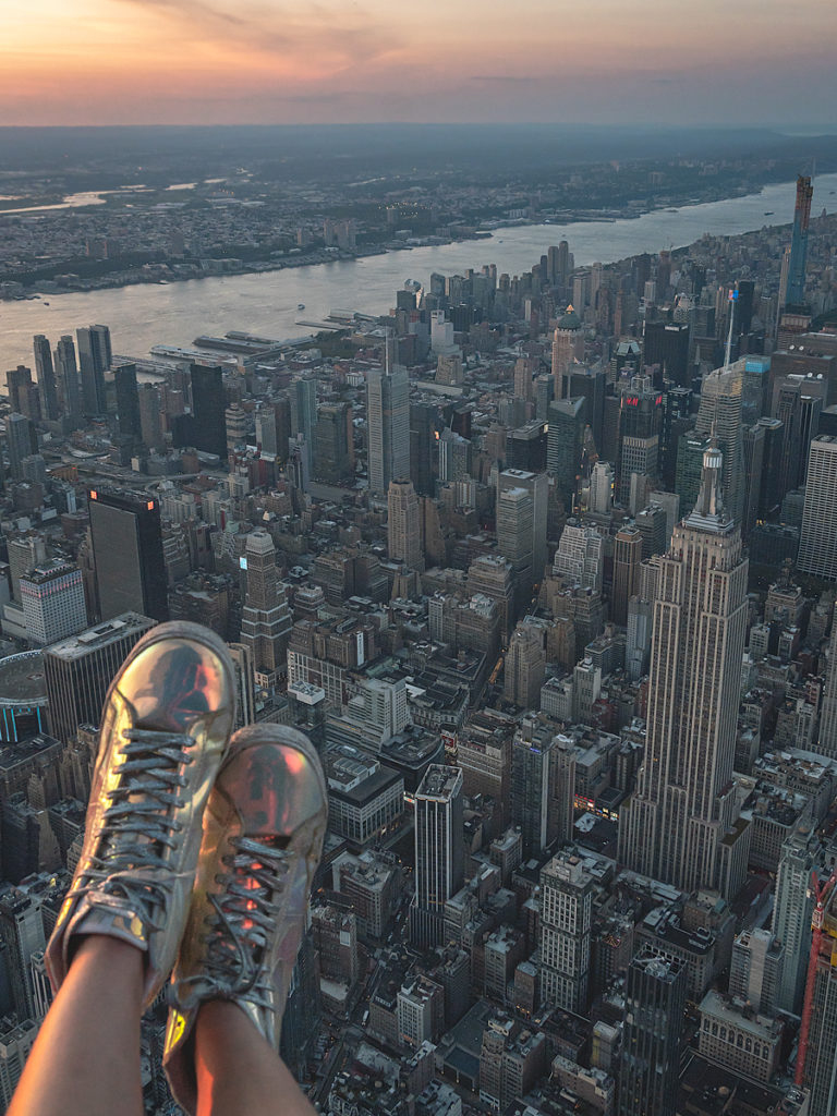 Sticking my feet out of the open door helicopter while photographing New York City.