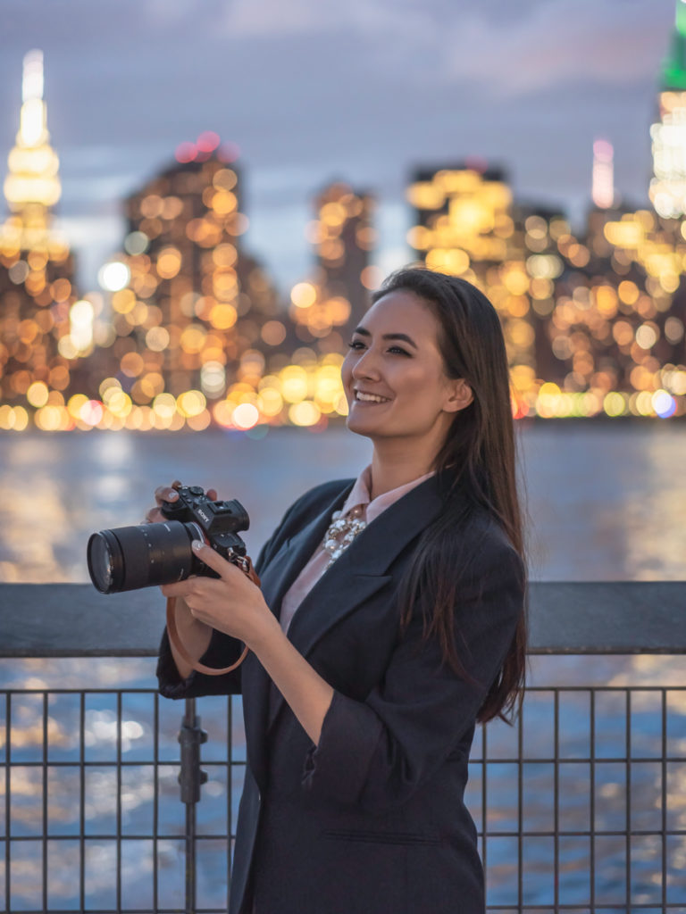 Personal branding photoshoot of Erin Donahue wearing a vintage Christian Dior blazer and holding a Sony a7iii at Gantry Plaza State Park.