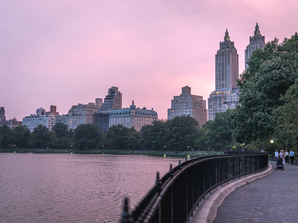 The famous tenants building El Dorado sticks out with a pink sunset behind it, making it one of the best Central Park photo spots.