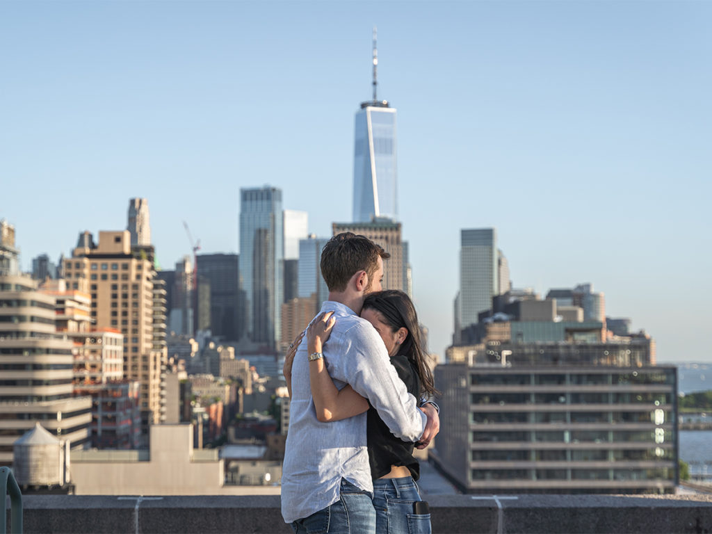 The couple embraces each other to savor the moment of their West Village rooftop engagement.