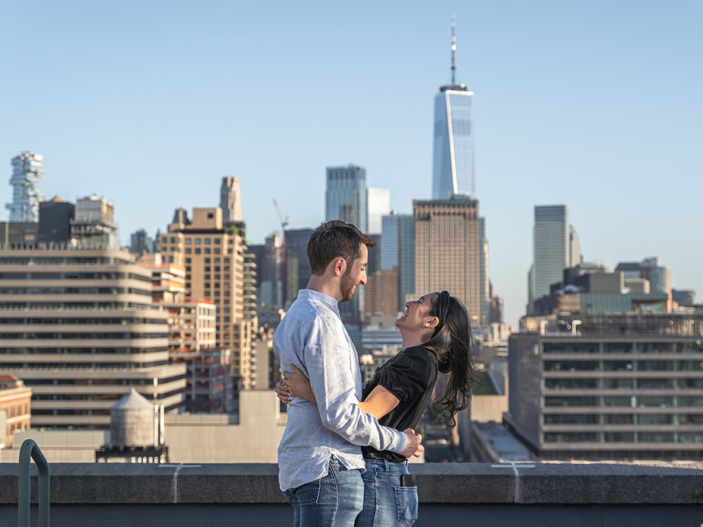 Happy candid moment between the couple during their West Village rooftop engagement. 