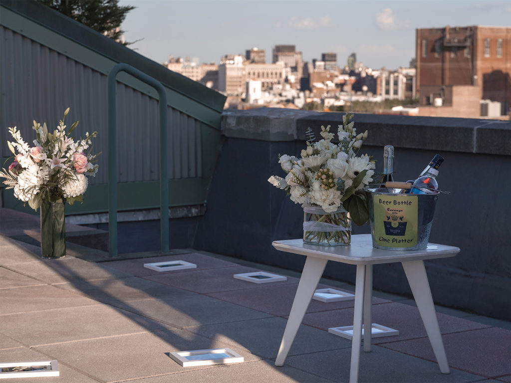 Two bouquets of flowers and other items on top of a West Village rooftop for a romantic proposal.