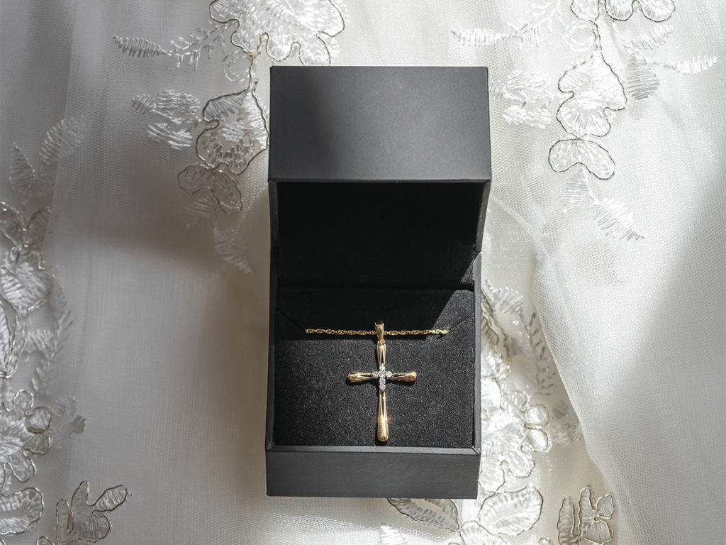 A cross in a black box with a lace background is the perfect gift for a baby's baptism.