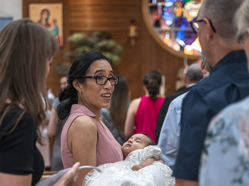 Photographing candid moments at a baby's baptism in Long Island.