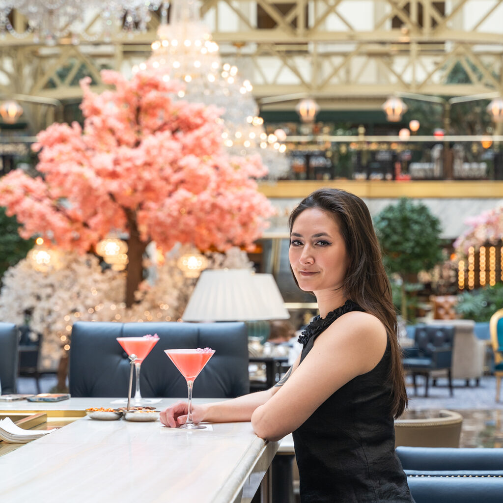 Drinking a Pink Lady cocktail at Peacock Alley with cherry blossom decorations in the Waldorf Astoria Washington D.C.