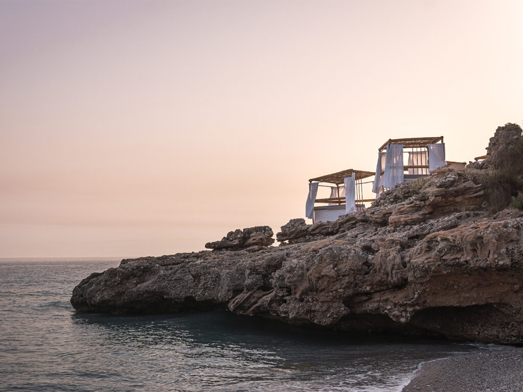 Cabanas sit atop cliffs at Dhermi Beach for a beautiful coastal retreat in Albania.