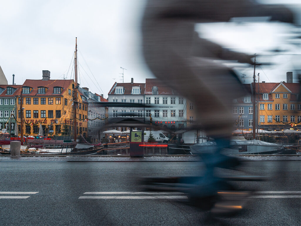 Visiting the Nyhavn waterfront as bikers pass is a must do during a one week Copenhagen itinerary.
