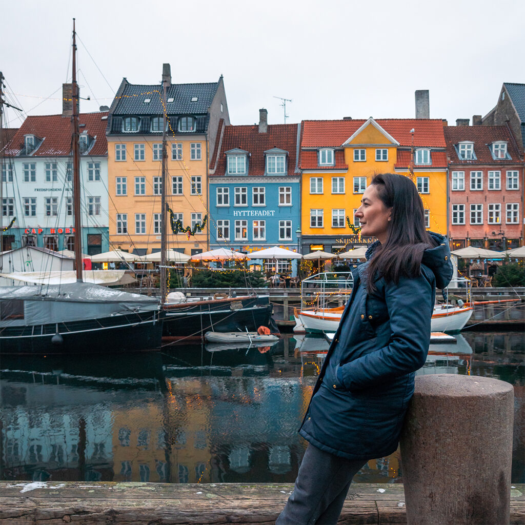Erin stands in front of the colorful Nyhavn waterfront to take pictures, which is a must do during a Copenhagen one week itinerary.