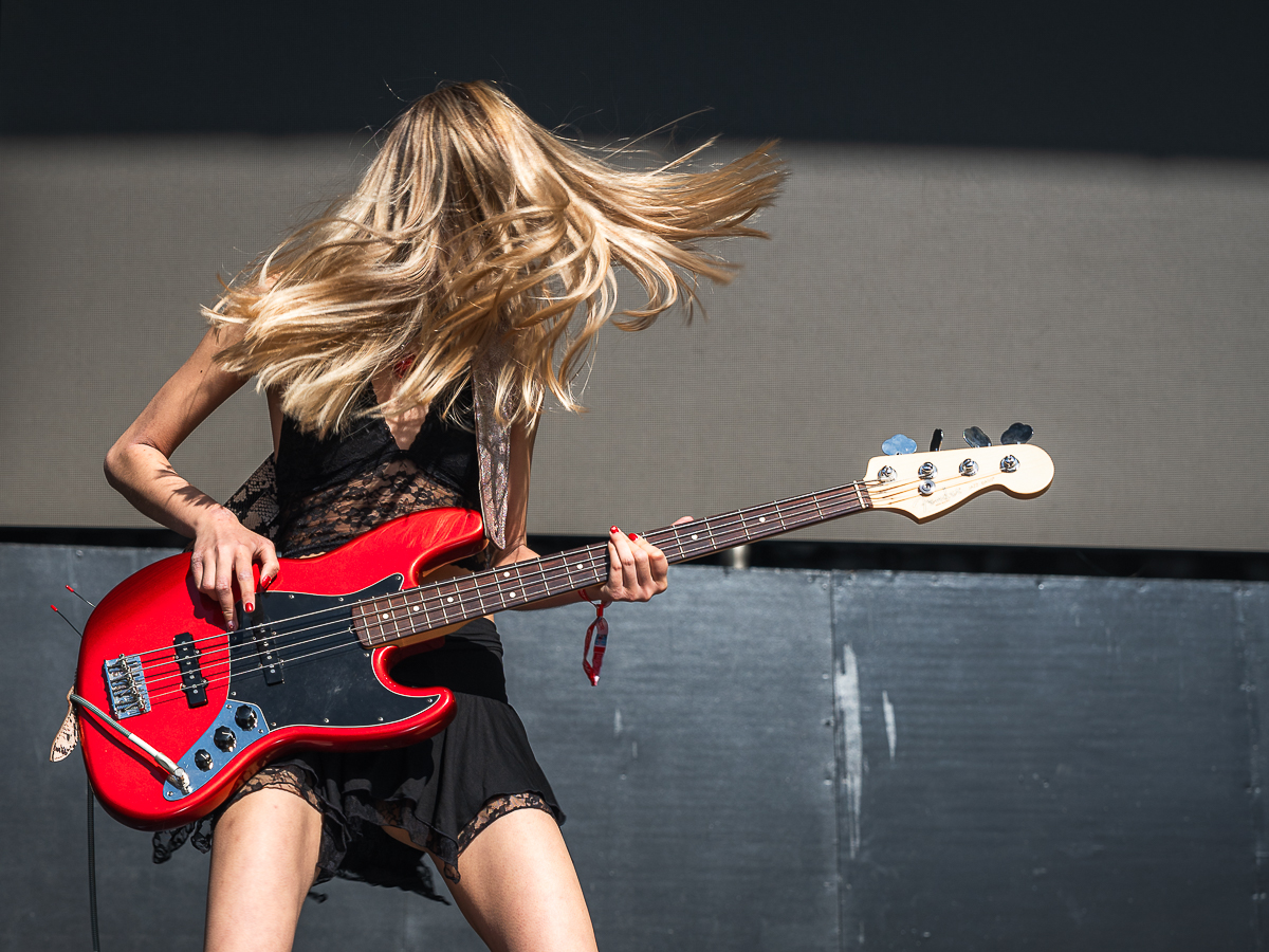 The bass guitarist for Lyn Lapid jams out with her hair flailing at Head in the Clouds festival.