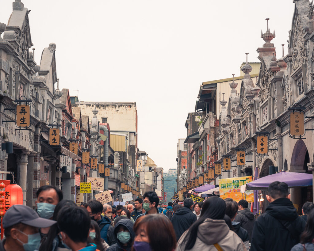 Crowds walk through the DaXi market's Qing Dynasty-era architecture.