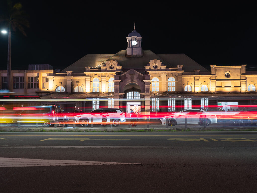 Hsinchu Train Station at night with light trails in front of it.